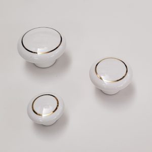 Puxadores em porcelana com aro dourado ou prateado.
