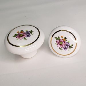 Puxador em porcelana flores com aro dourado.